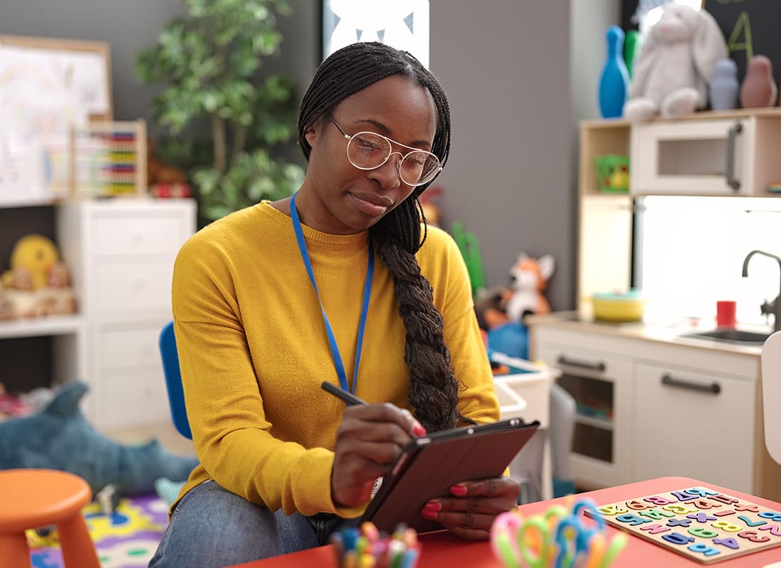 Service Center - Portrait of a Young African American Kindergarten Teacher Using a Tablet